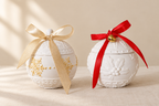 Las dos velas con lazos crema y rojo sobre fondo cálido